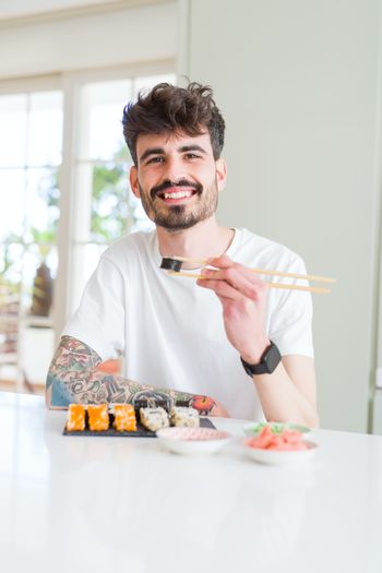 Happy man eating sushi